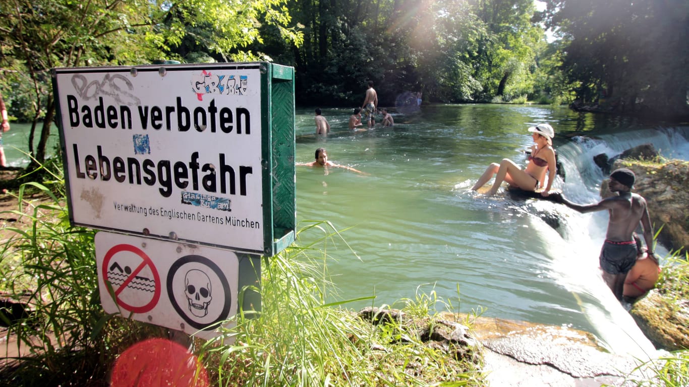 "Baden verboten" steht auf einem Schild am Eisbach (Archivbild): Dennoch gehen viele Menschen im Englischen Garten baden – und begeben sich damit in tödliche Gefahr.