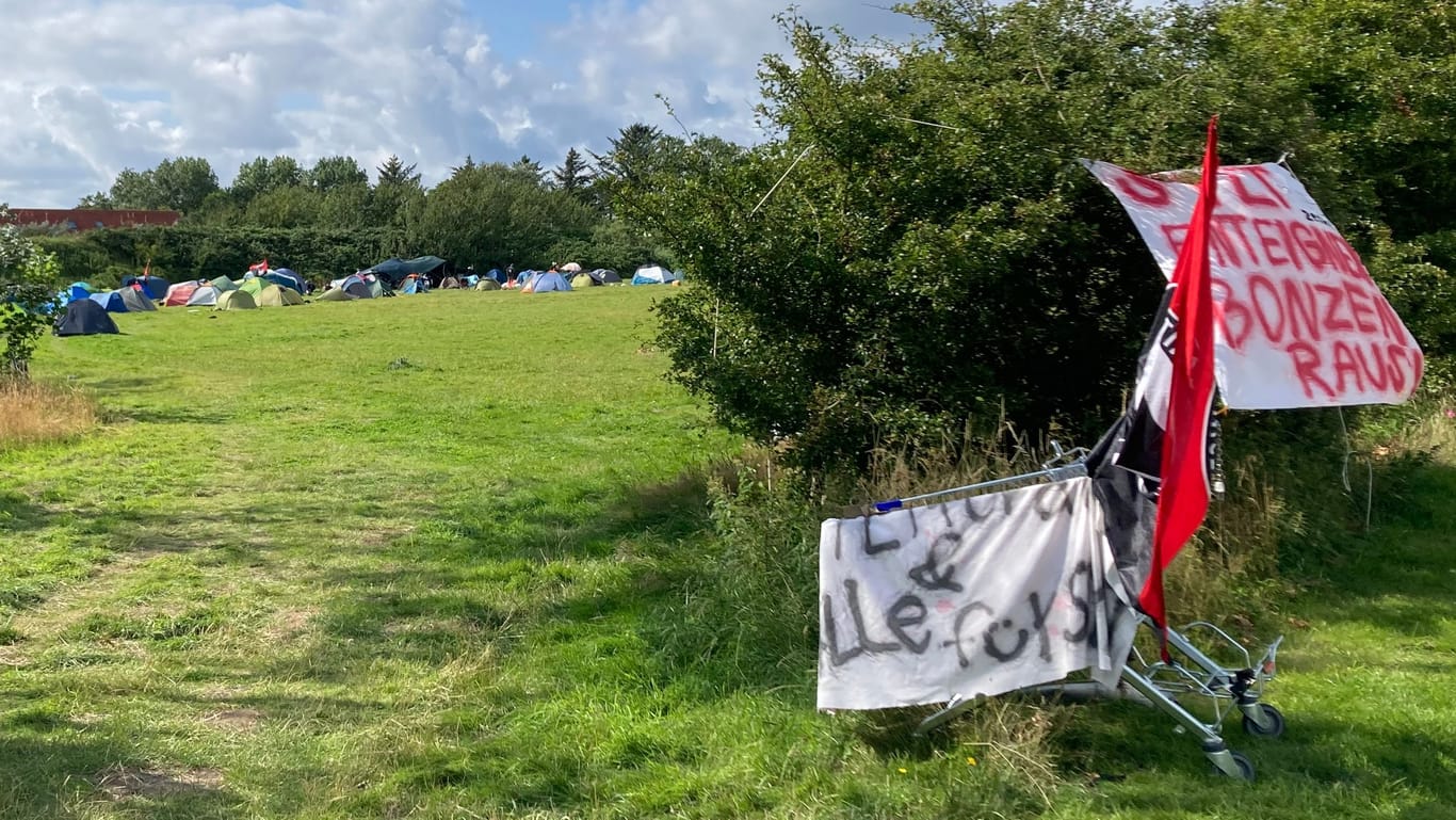 Campingplatz statt Luxushotel: Protestbanner an einem Einkaufswagen weisen den Weg zum Zeltlager der Punker.