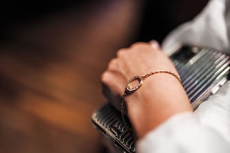 A gold bracelet with diamonds on a chain on the hand of a woman