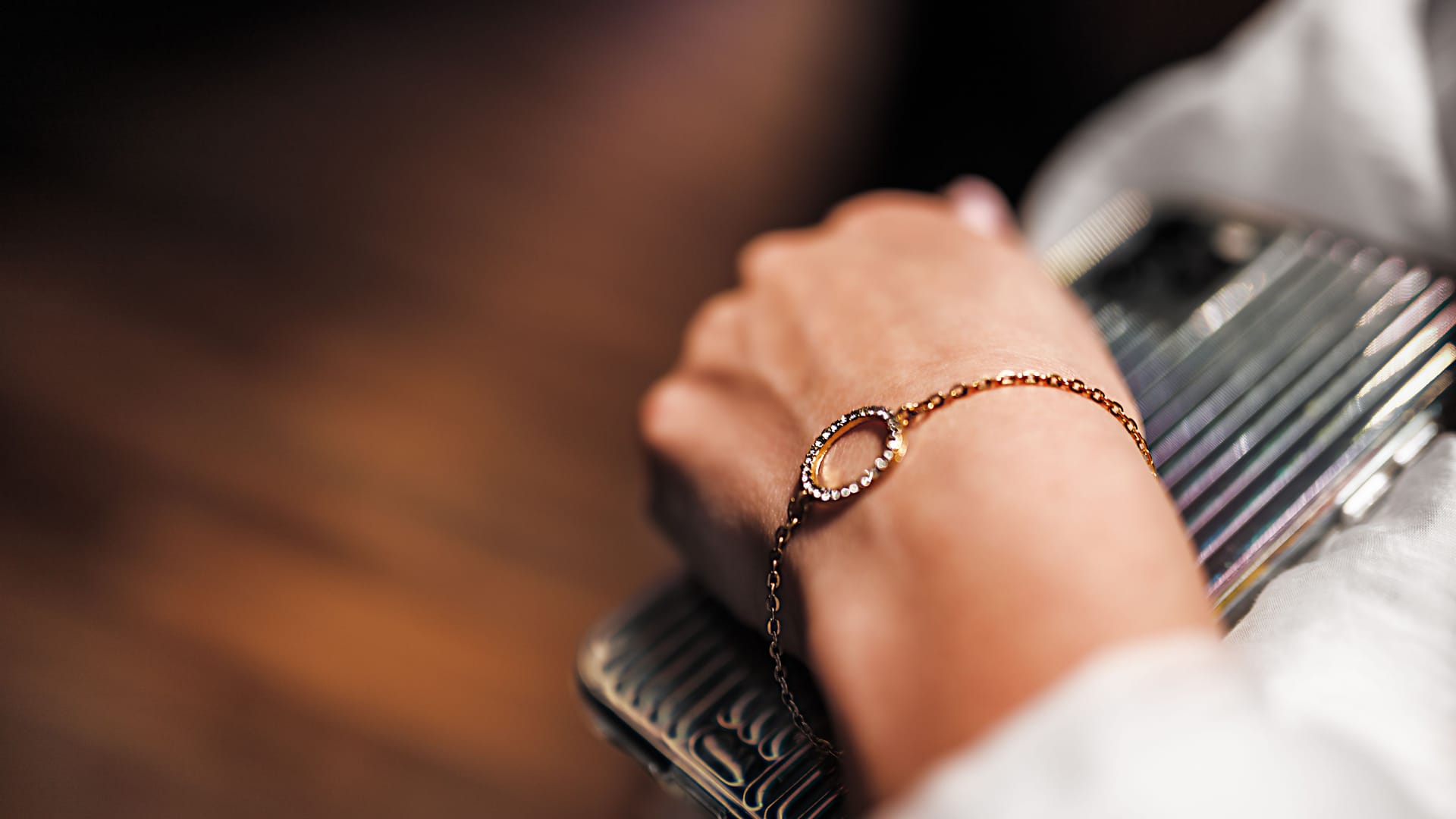 A gold bracelet with diamonds on a chain on the hand of a woman