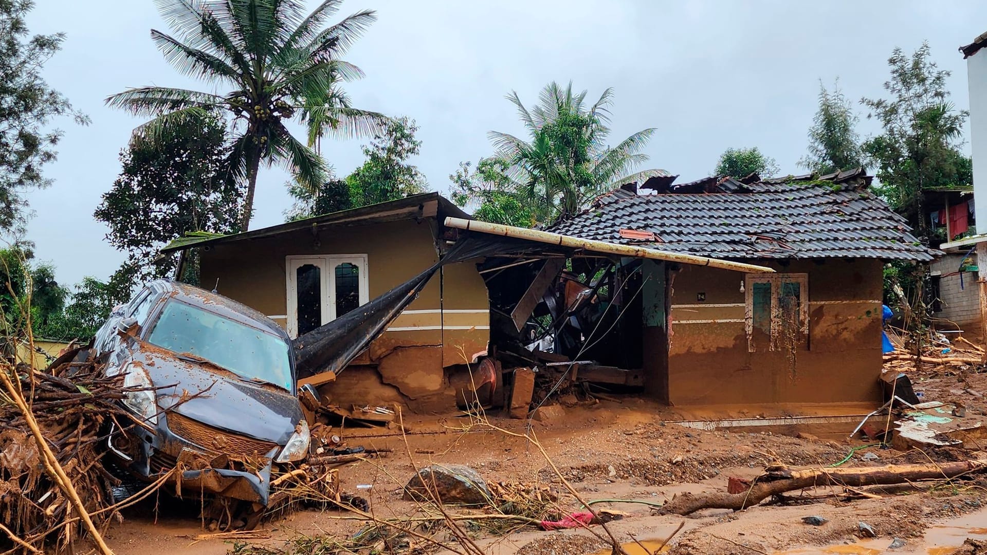 Ein beschädigtes Auto und ein Haus nach einem Erdrutsch in einem Bergdorf im Bezirk Wayanad: Die Naturkatastrophe forderte viele Tote.