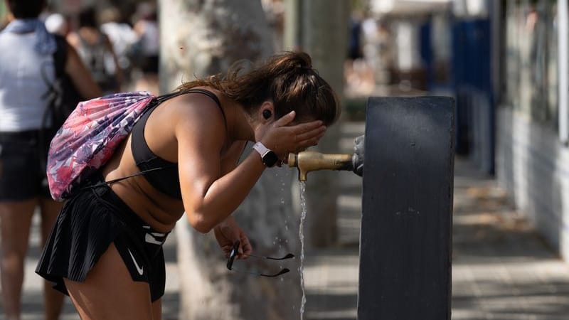 Eine Frau sucht Erfrischung an einem Wasserbrunnen in der Stadtmitte. Nach Angaben der staatlichen meteorologischen Agentur Aemet werden in Barcelona hohe Temperaturen erwartet.