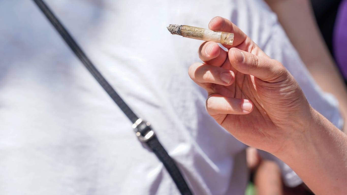 Eine Person hält einen Joint in der Hand (Symbolbild): CDU-Chef Dennis Thering attackiert die Cannabis-Freigabe scharf.