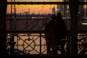Ein Paar genießt den Sonnenuntergang auf einer Eisenbahnbrücke (Symbolbild): Ob die Aktion für den Mann und die Frau Konsequenzen hat, prüft nun die Polizei.