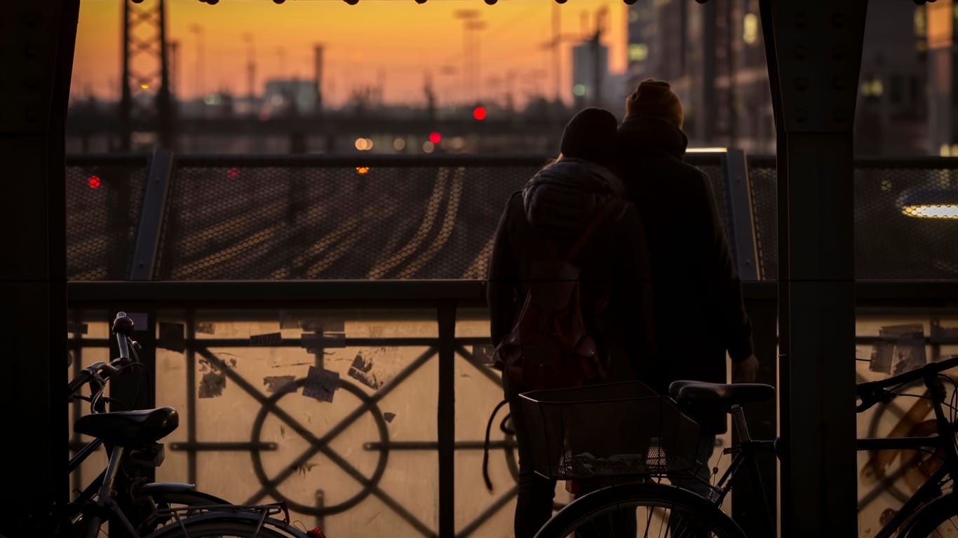 Ein Paar genießt den Sonnenuntergang auf einer Eisenbahnbrücke (Symbolbild): Ob die Aktion für den Mann und die Frau Konsequenzen hat, prüft nun die Polizei.