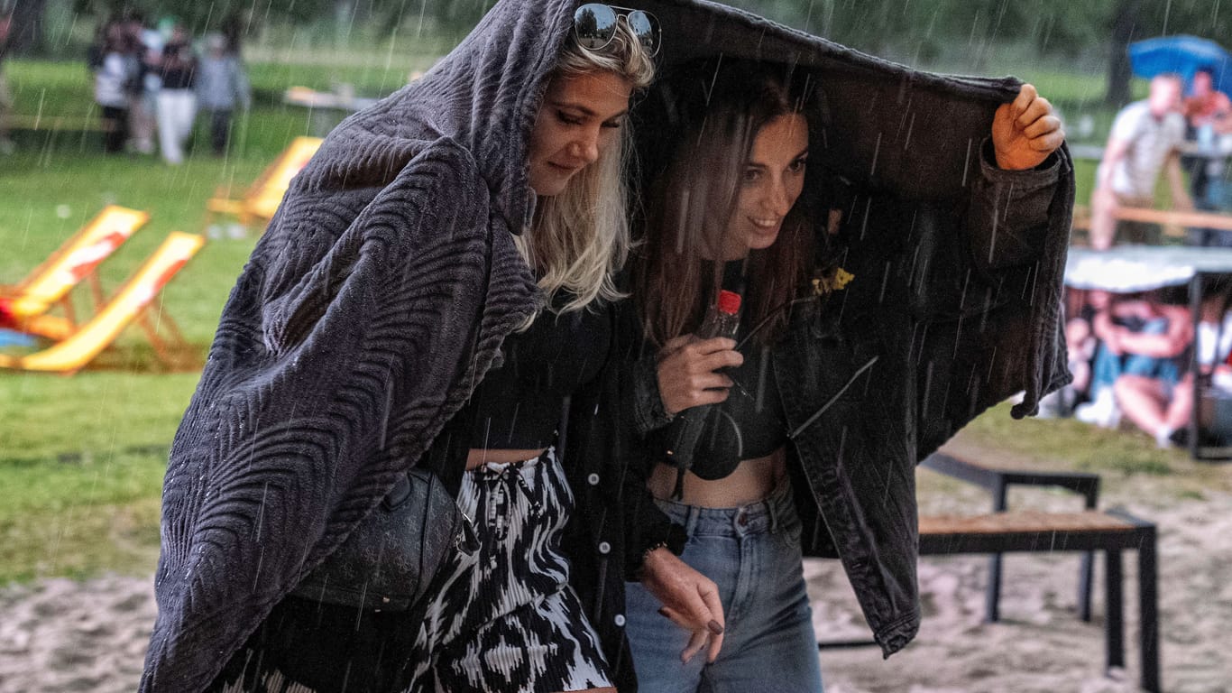 Zuschauer suchen beim Public Viewimg Schutz vor dem Regen im Solimare Freibad in Moers: Mit gutem Wetter wurde das EM-Publikum bisher eher selten verwöhnt.