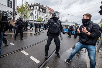 Ein Polizeibeamter bei einer körperlichen Auseinandersetzung mit dem Teilnehmer einer Demo in München (Archivbild).