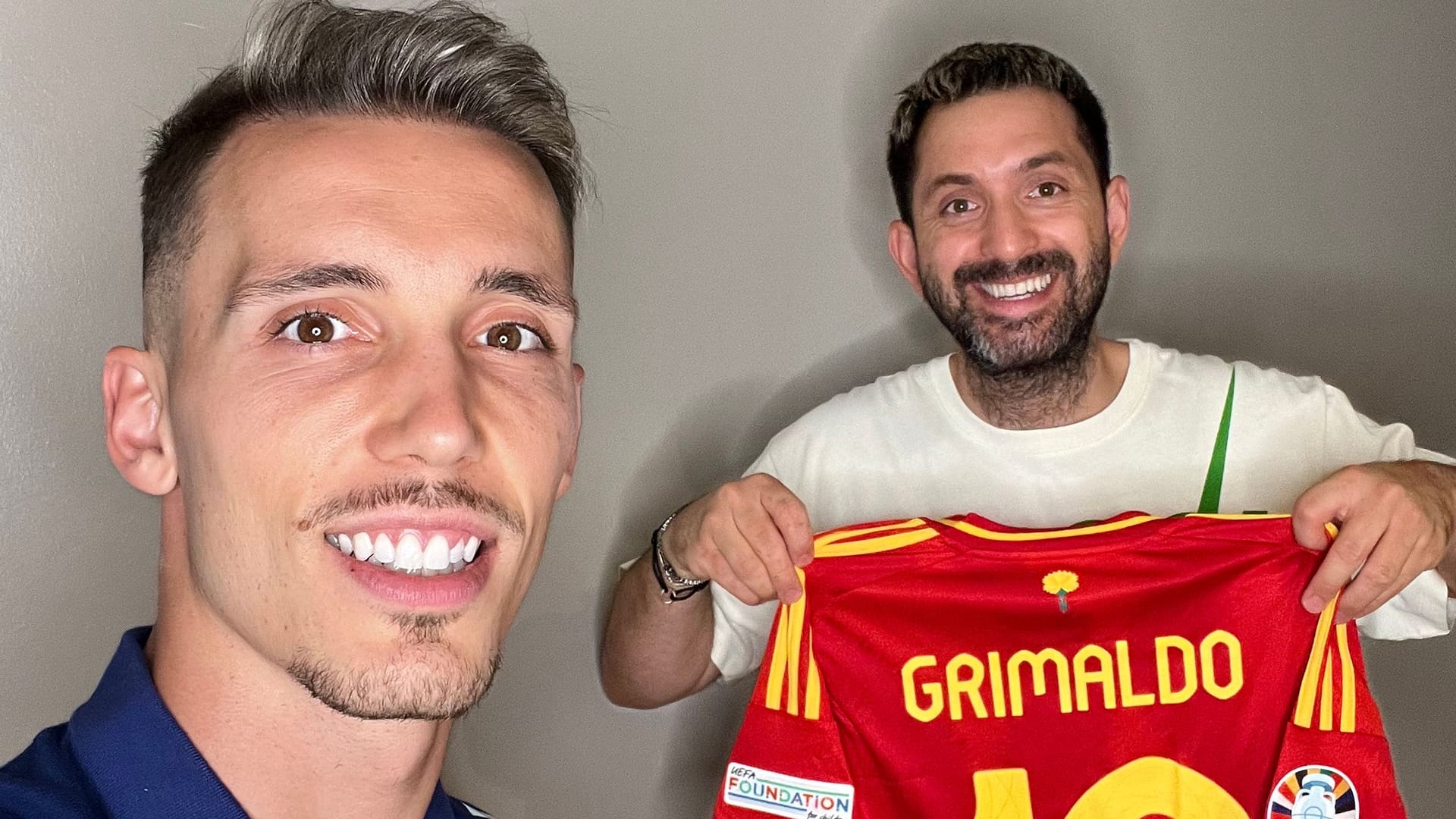 Ein Trikot als Dankeschön: Spaniens Alejandro Grimaldo mit dem Düsseldorfer Friseur Melih Benderlioglu (rechts).