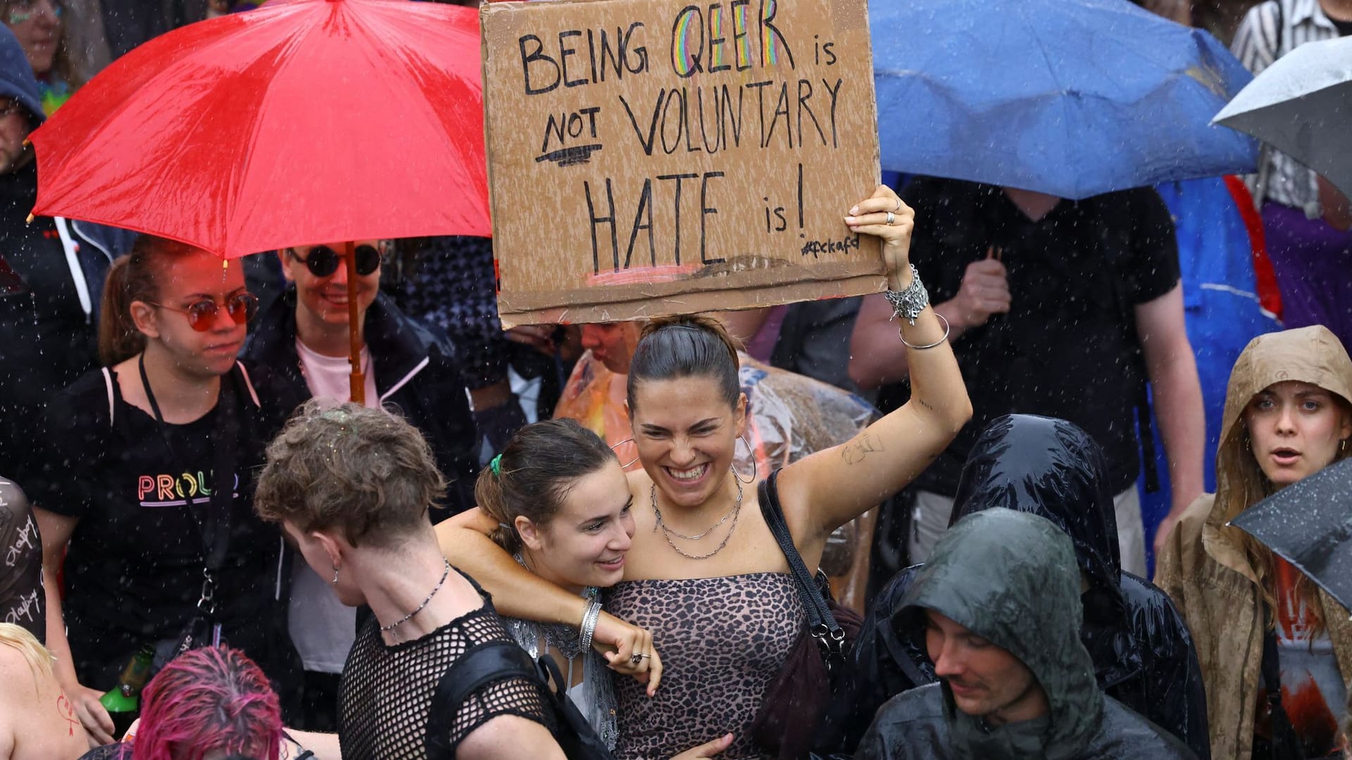 Teilnehmer des CSD halten ein Plakat hoch. Trotz Regens kamen hunderttausende Besucher in die Hauptstadt.