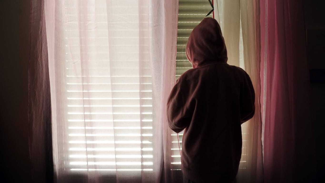 Ein Kind steht vor einem Fenster (Symbolbild): Der Kinder-Notdienst in Hamburg steht vor großen Problemen, zeigen aktuelle Zahlen.