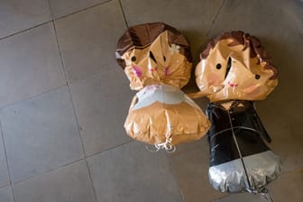 Luftballons in Form eines Brautpaars hängen an einer Decke