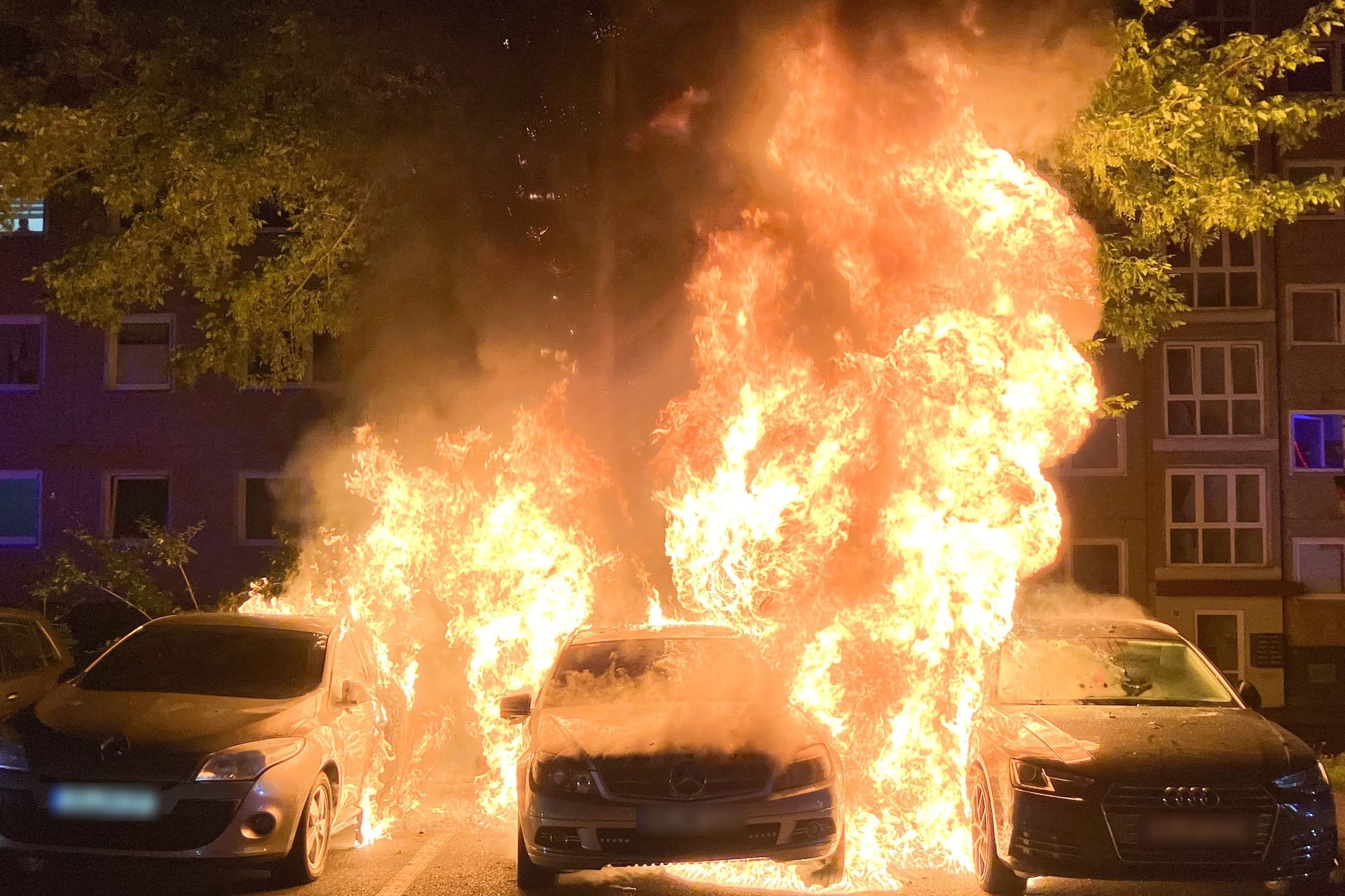 Drei Autos stehen auf dem Otto-Dix-Ring in Flammen: Durch die enorme Hitze war der Tank des Mercedes undicht geworden: In Brand geratener Kraftstoff drohte weiter überzugreifen.