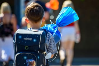 Kind mit blauer Schultüte und Ranzen auf dem Schulhof (Symbolbild): Die Erstklässler sollen trotz der Umstände wie geplant eingeschult werden.