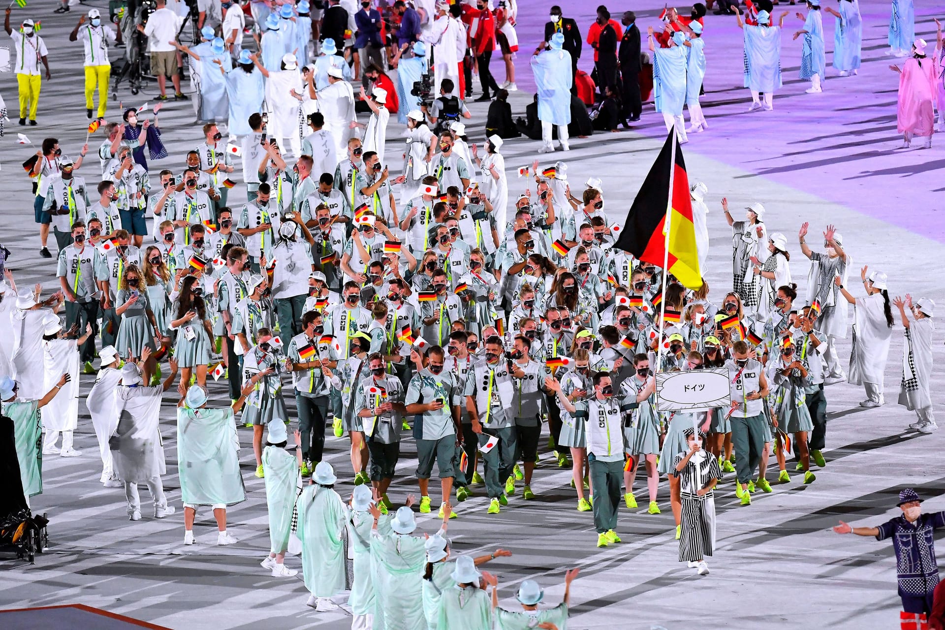 Laura Ludwig und Patrick Hausding tragen die Fahne ins Stadion von Peking 2022