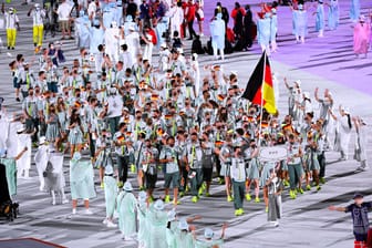Laura Ludwig und Patrick Hausding tragen die Fahne ins Stadion von Peking 2022