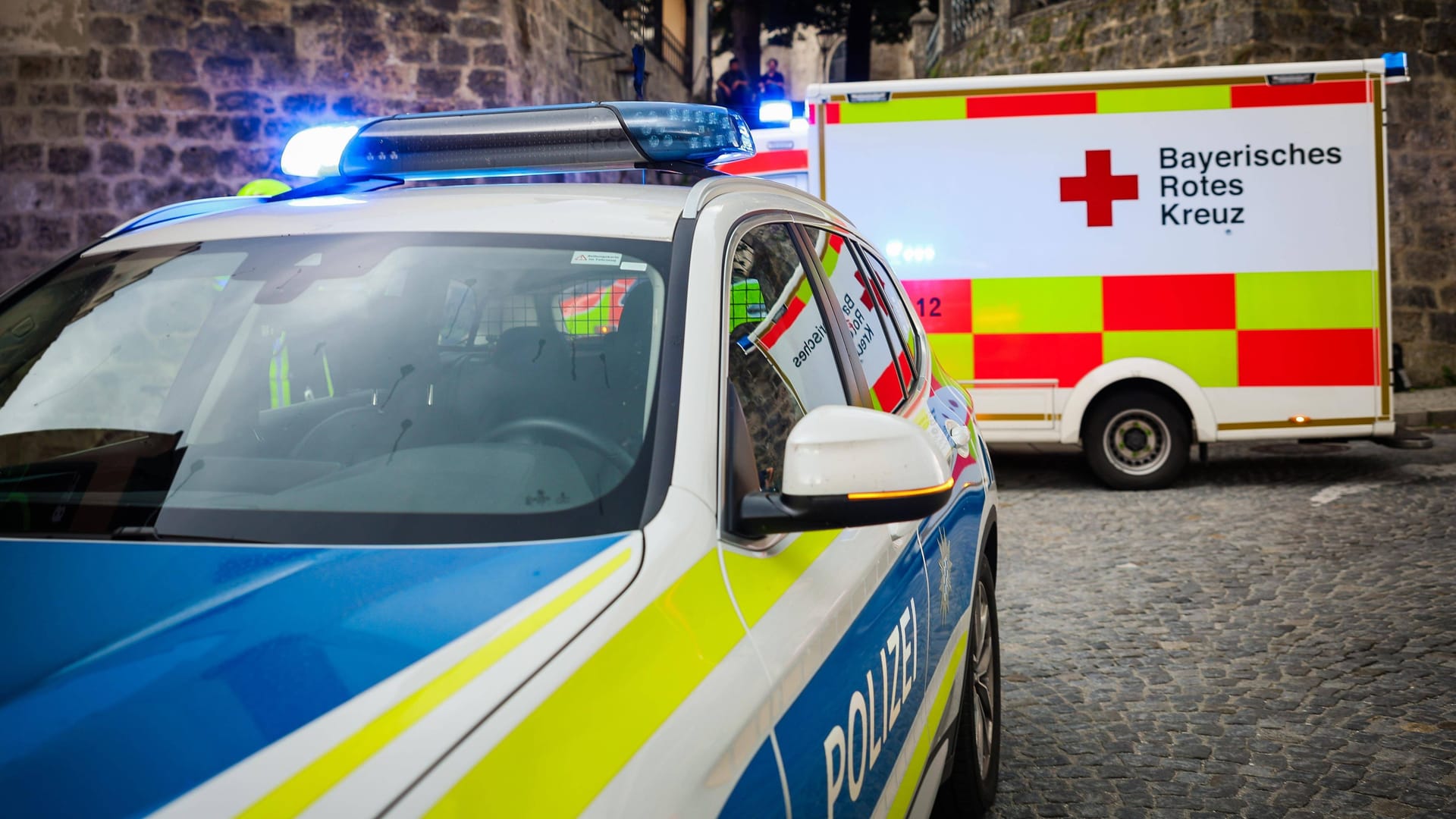 Ein Polizeiauto und ein Krankenwagen (Symbolbild): Bei der Fahrt verletzt der unbekannte Autofahrer zwei Menschen.