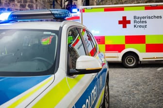 Ein Polizeiauto und ein Krankenwagen (Symbolbild): Bei der Fahrt verletzt der unbekannte Autofahrer zwei Menschen.