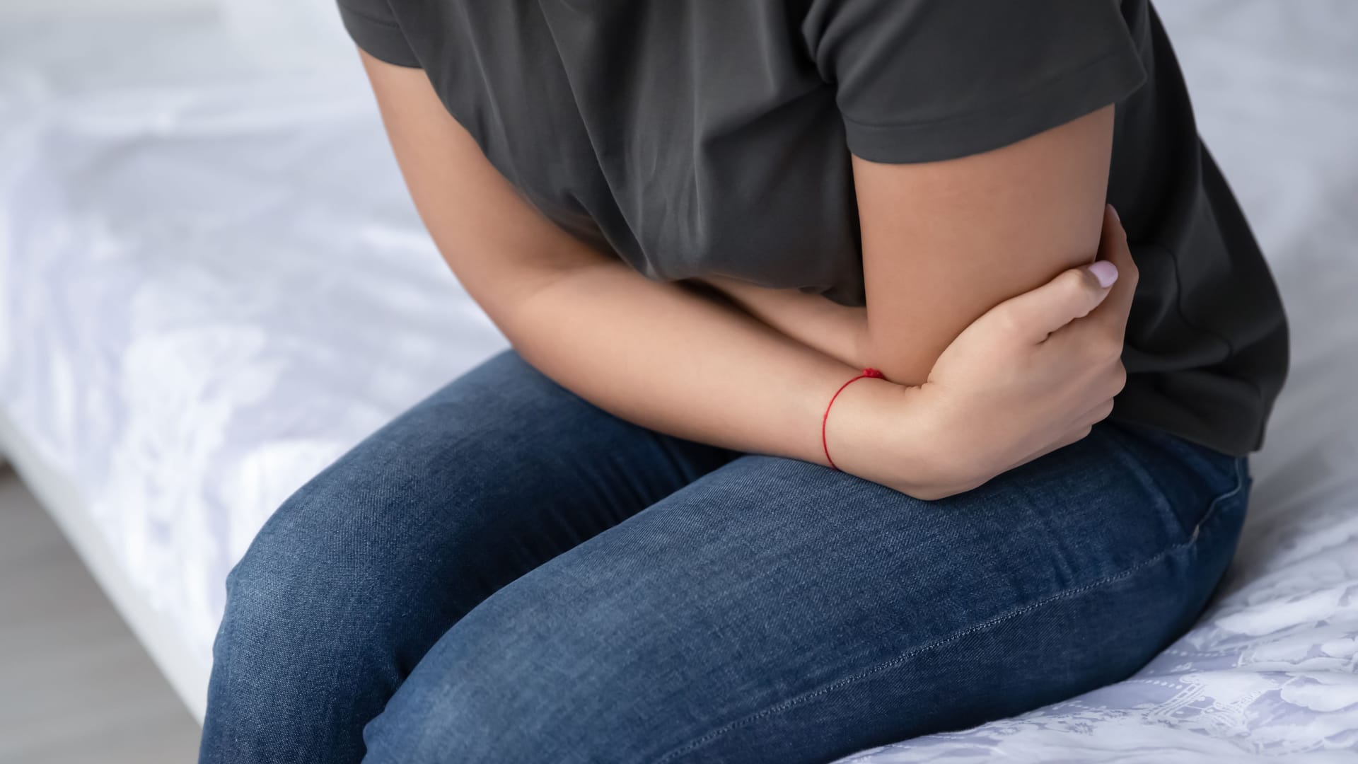 Eine Person hält sich die Arme vor den Bauch