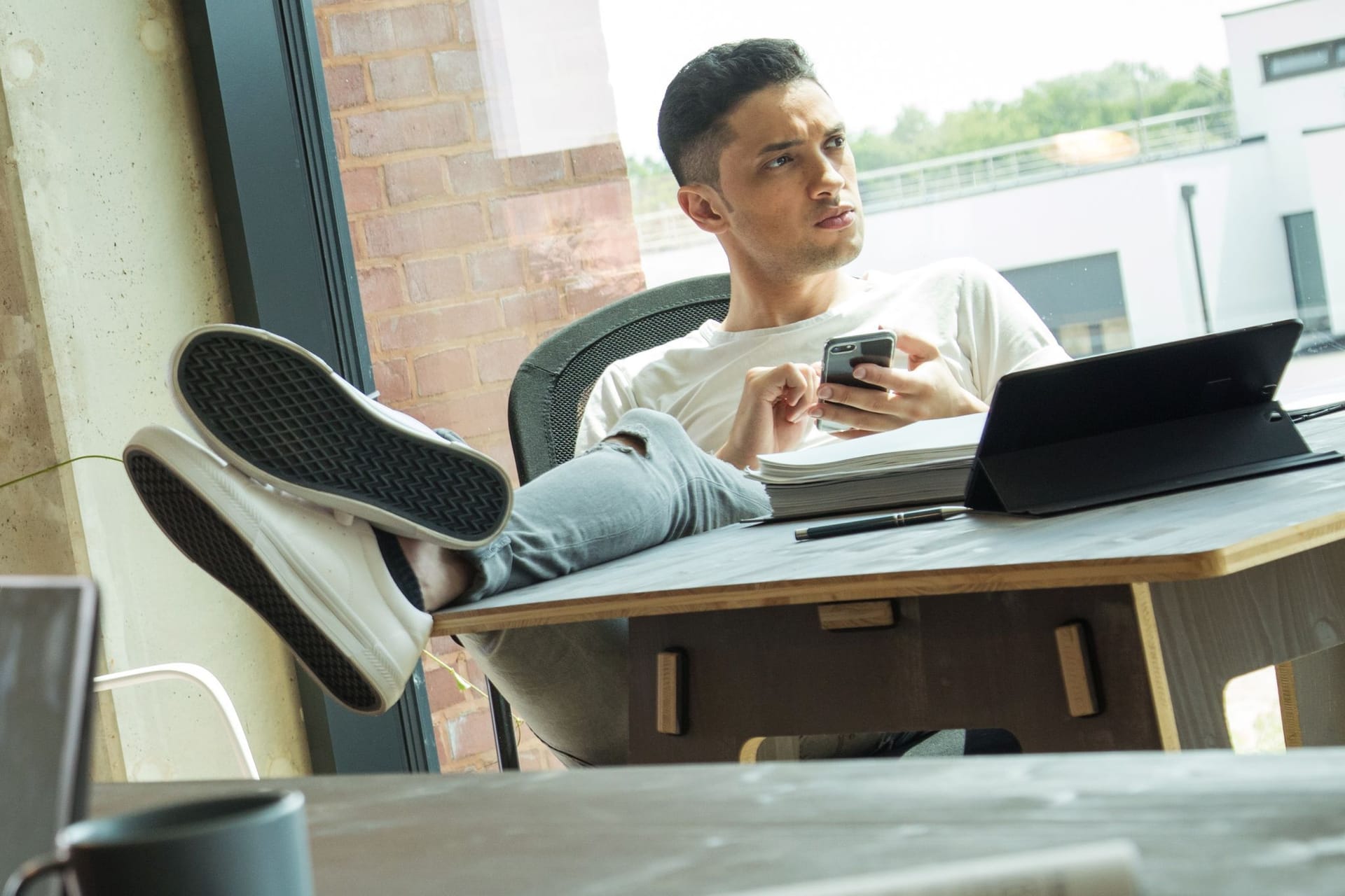 Mann sitzt am Schreibtisch Mann sitzt am Schreibtisch
