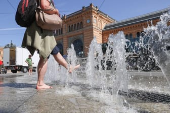 Eine Passantin kühlt sich am Brunnen vor dem Hauptbahnhof ab (Symbolbild): In Hannover wird es am Dienstag sehr warm.