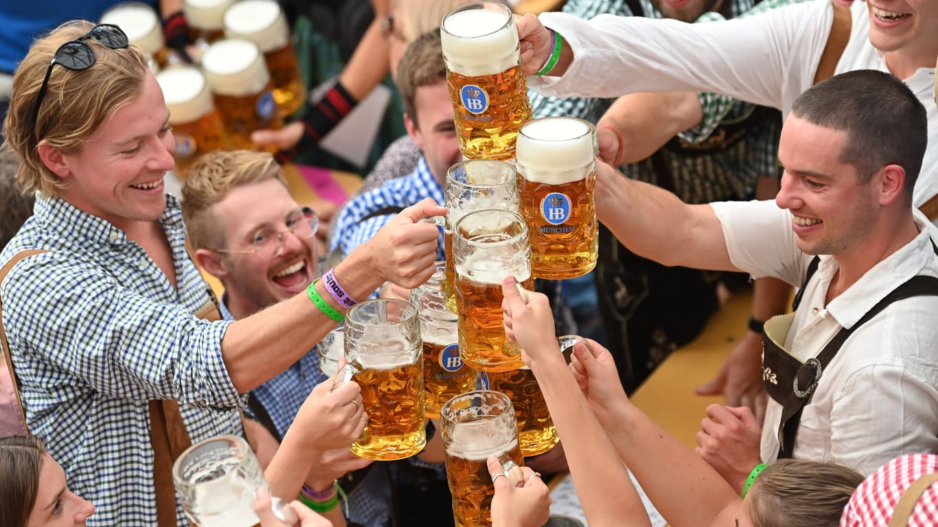 Menschen stoßen beim Oktoberfest mit Bier an (Archivbild): Ob der erneut gestiegene Maßpreis die Wiesnbesucher abschreckt, wird sich erst noch zeigen.