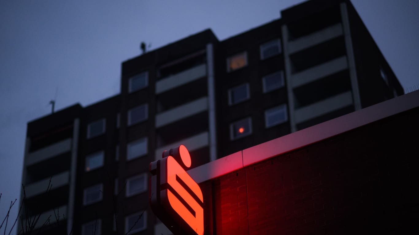 Ein Logo der Sparkasse leuchtet an einer Filiale