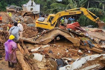 Katastrophe im Bezirk Wayanad: Retter stehen inmitten von Trümmern, nachdem Erdrutsche hügelige Dörfer getroffen haben.