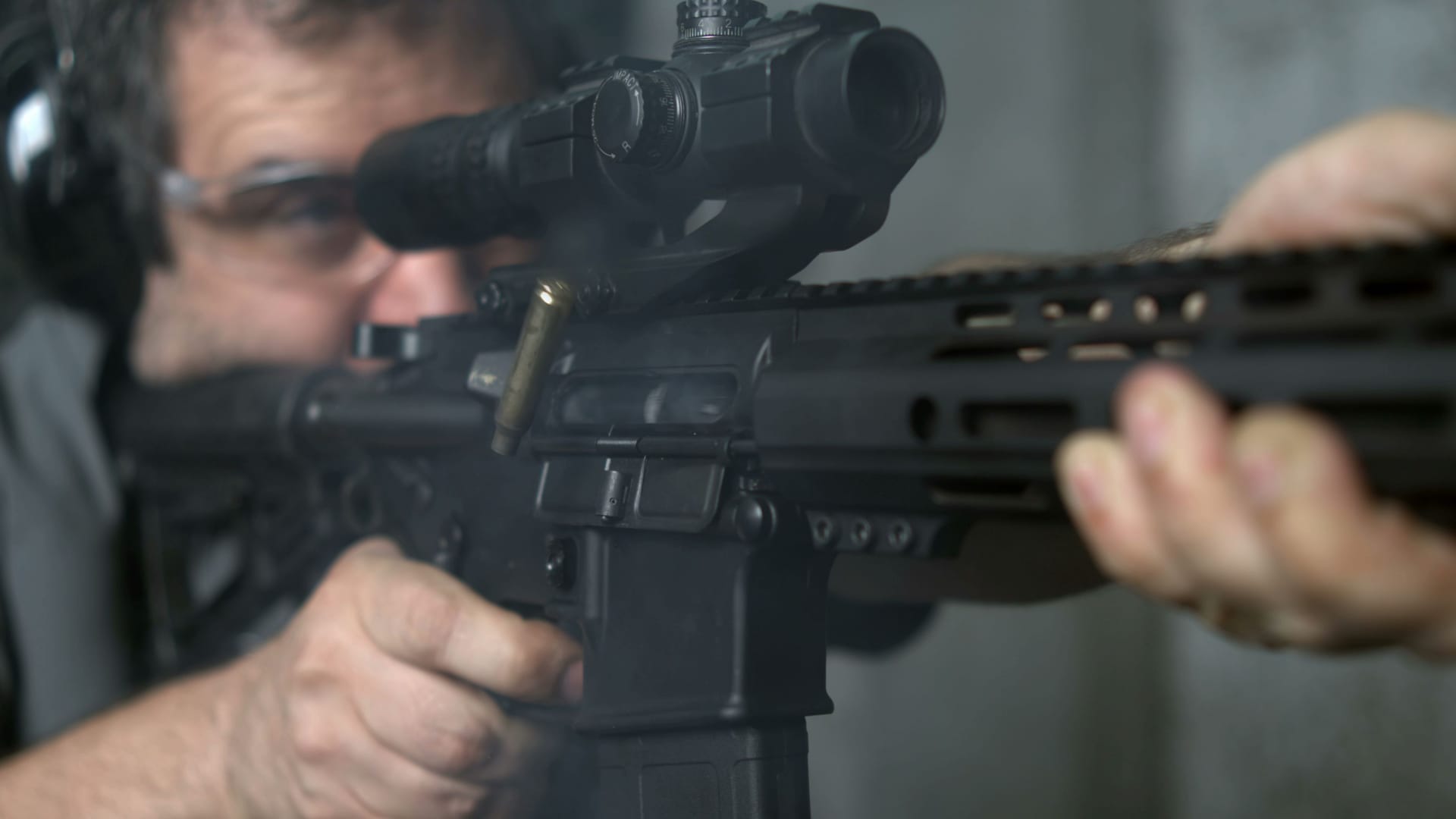 Firing an Assault rifle in super slow-motion 800 fps. Person shooting with AR-15 detail close-up of gun