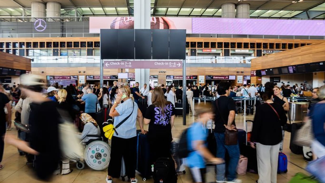 In der Haupthalle des BER bilden sich lange Schlangen vor den Check-in-Schaltern.