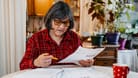 Rentnerin prüft ihre Finanzen: Auch im Ruhestand gilt die Steuerpflicht.