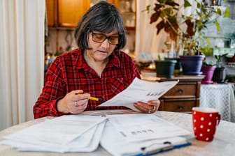 Rentnerin prüft ihre Finanzen: Auch im Ruhestand gilt die Steuerpflicht.