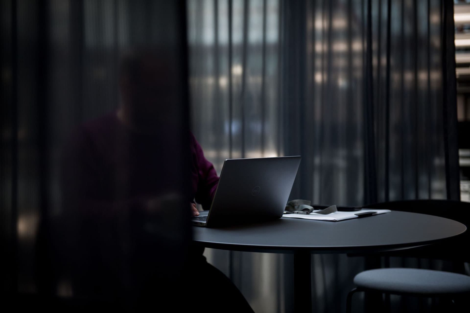 Person arbeitet an einem Laptop im Büro Person arbeitet an einem Laptop im Büro
