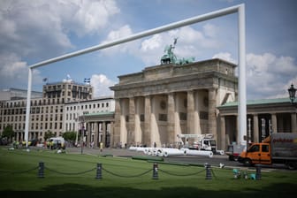 ARCHIV - 21.05.2024, Berlin: Kunstrasen liegt während einer Pressekonferenz zu Fanzonen bei der Fußball-Europameisterschaft 2024 bereits vor einem riesigen Tor vor dem Brandenburger Tor auf der Fanmeile.