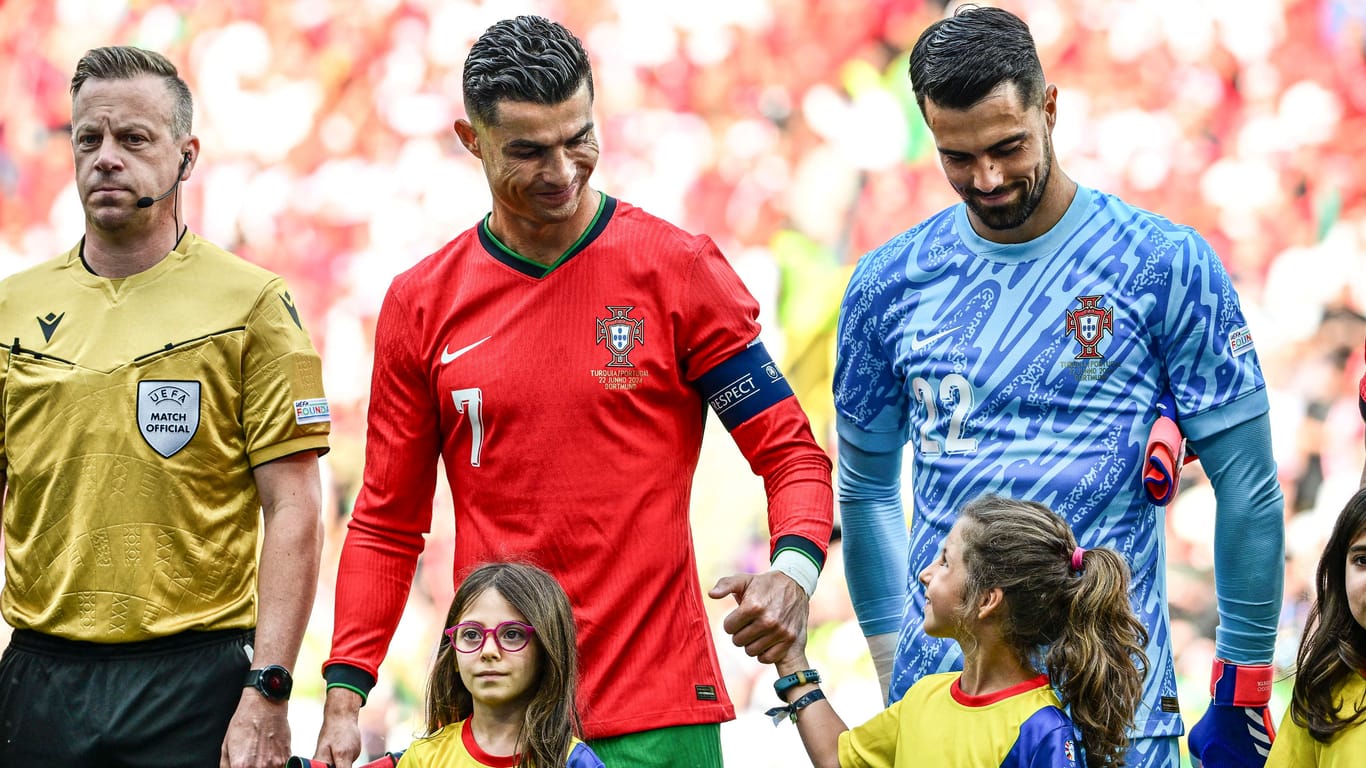 Cristiano Ronaldo mit einem glücklichen Einlaufkind bei der Partie Türkei gegen Portugal.