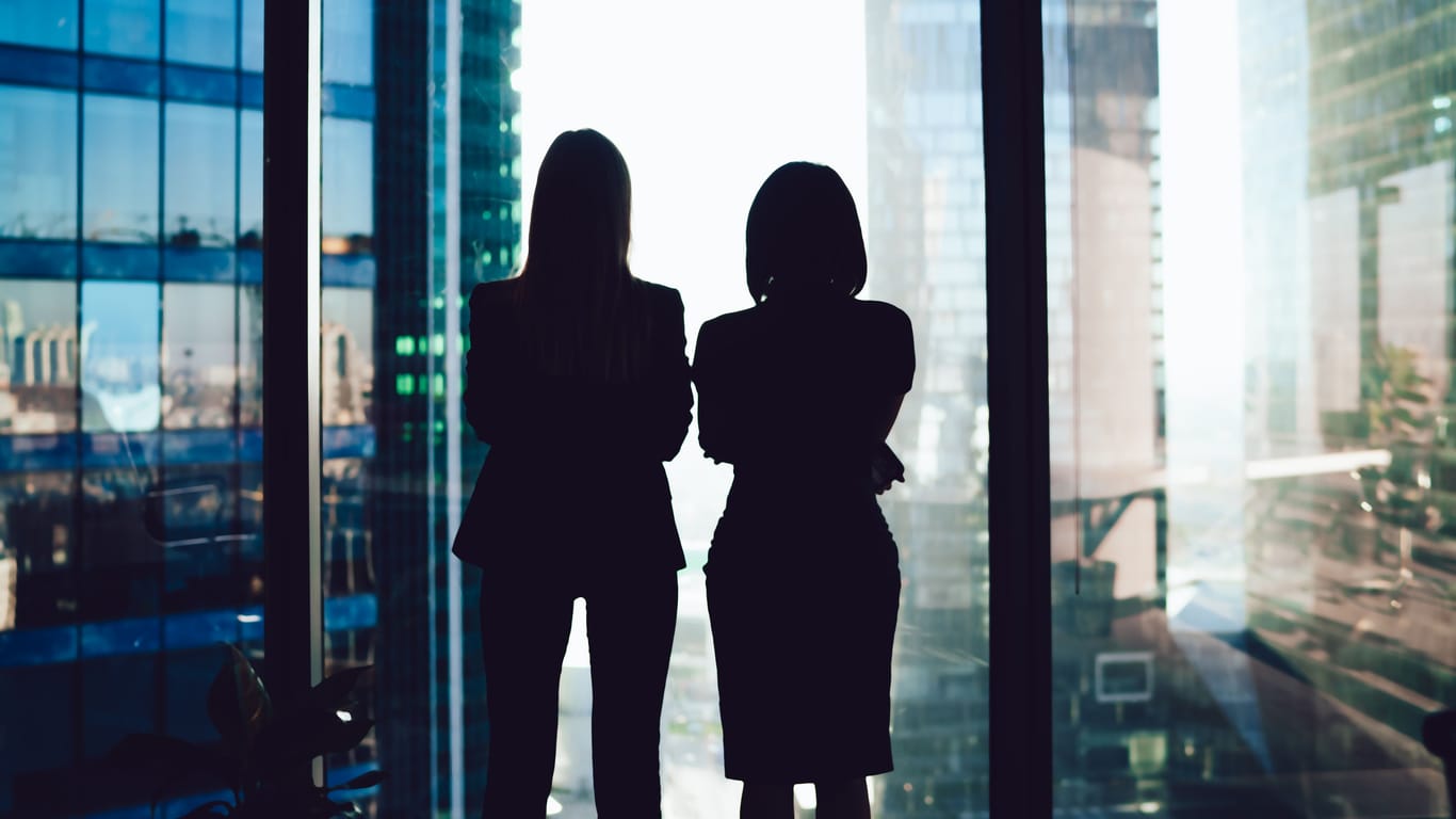 Zwei Frauen schauen aus dem Fenster eines Büros (Symbolbild): Berlin hat die meisten Frauen in Führungspositionen öffentlicher Unternehmen im Bundesländervergleich.