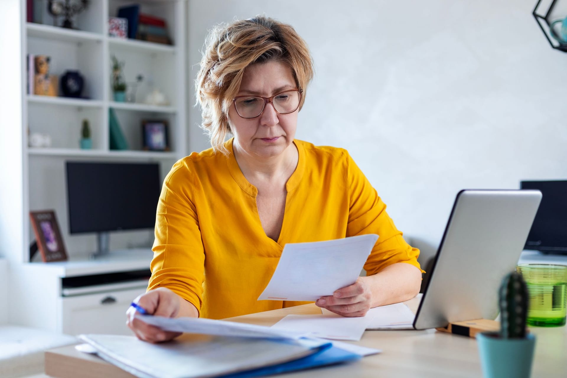 Eine Frau prüft ihre Finanzen: Die Höhe der Witwenrente hängt auch vom eigenen Einkommen ab.