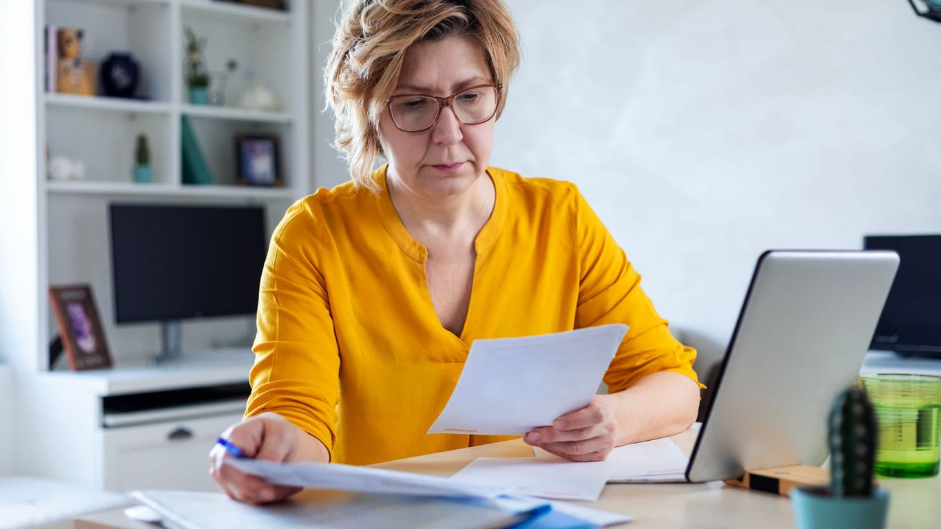 Eine Frau prüft ihre Finanzen: Die Höhe der Witwenrente hängt auch vom eigenen Einkommen ab.