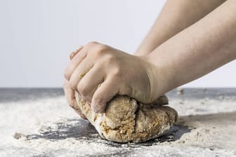 Eine Frau knetet einen Brotteig (Symbolbild).