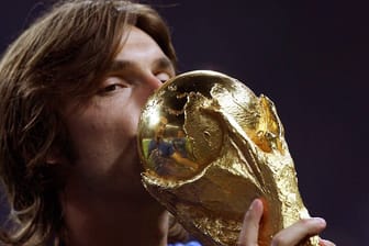 Wer versteckt sich da hinter dem WM-Pokal? Es ist Italiens Legende Andrea Pirlo.