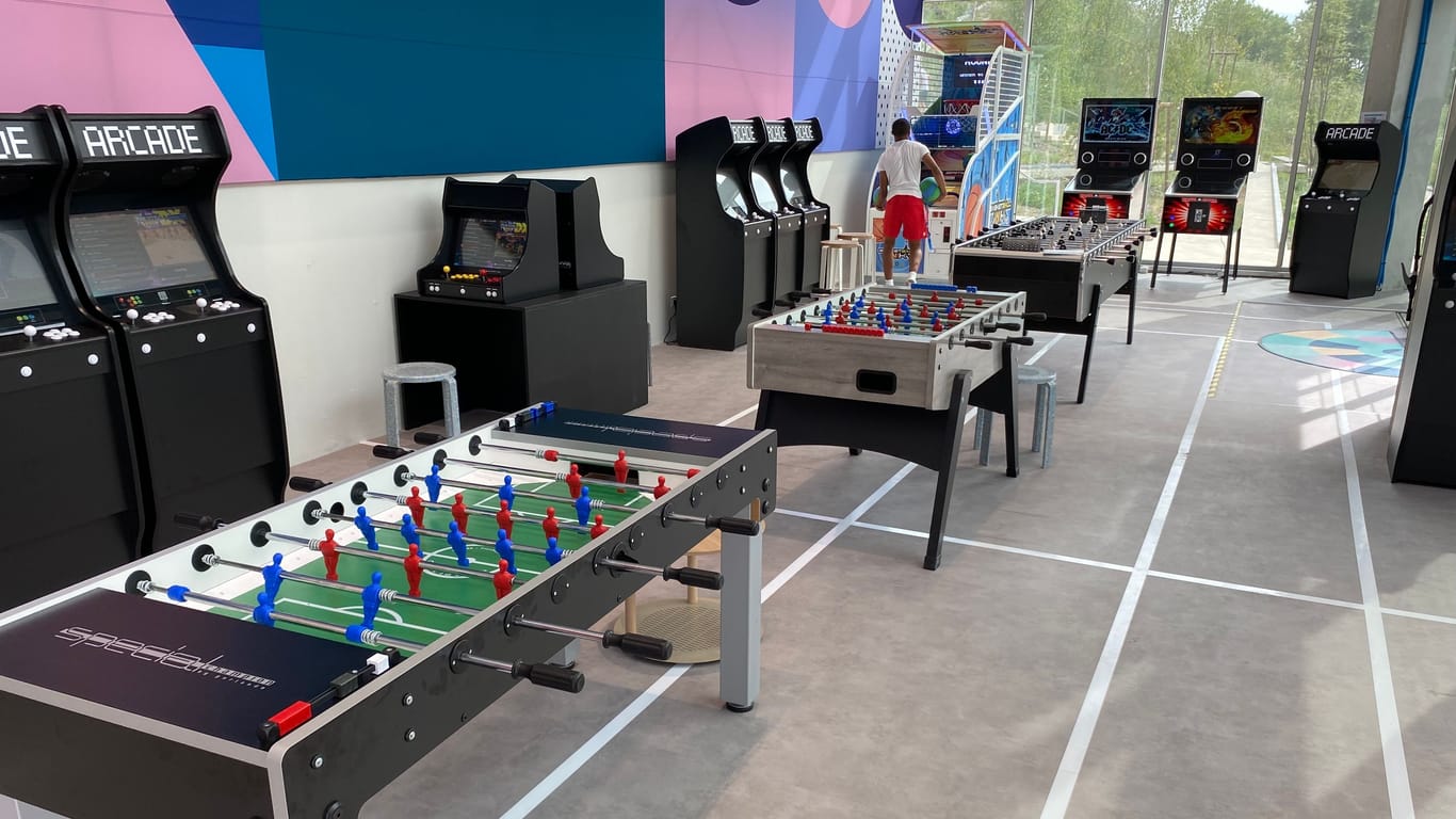 In der Spielhalle des Olympischen Dorfes gibt es neben Arcade-Automaten auch Kicker- und Air-Hockey-Tische.