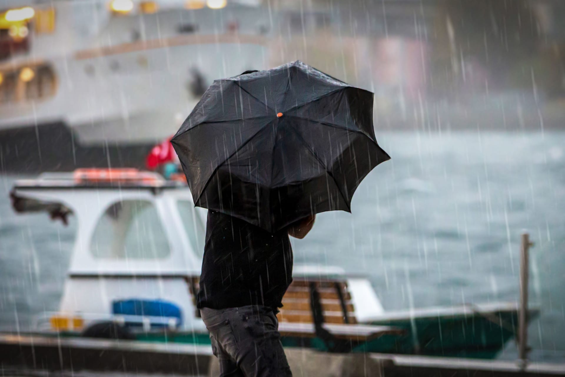 Ein Mann hält einen Regenschirm (Symbolbild): Mit stürmischen Böen ist ein großes Gewitter am Samstag über Hamburg gezogen.