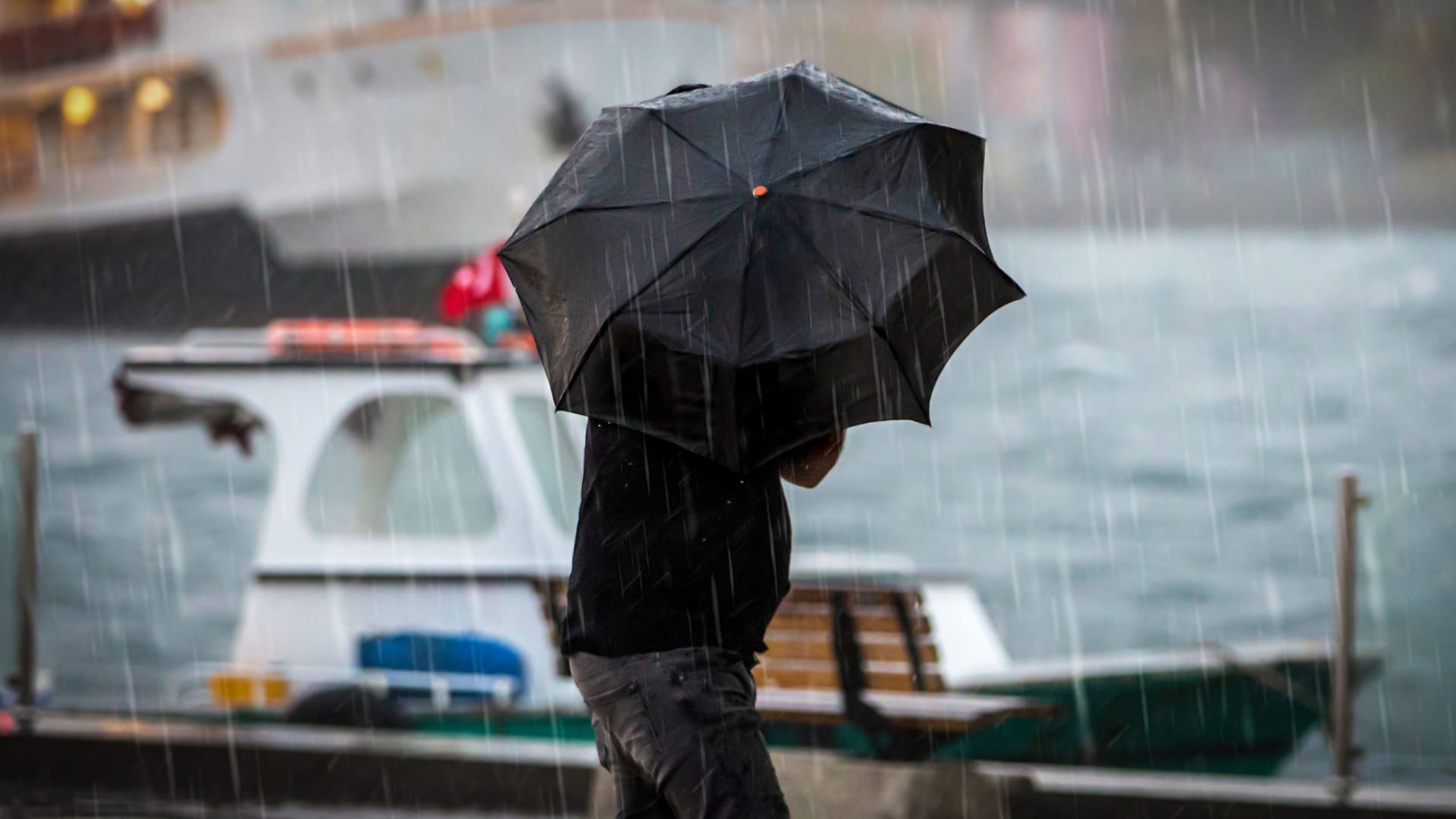 Ein Mann hält einen Regenschirm (Symbolbild): Mit stürmischen Böen ist ein großes Gewitter am Samstag über Hamburg gezogen.