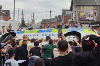 Randalierer werfen in Leeds ein Polizeiauto um. Es kam zu schweren Ausschreitungen.