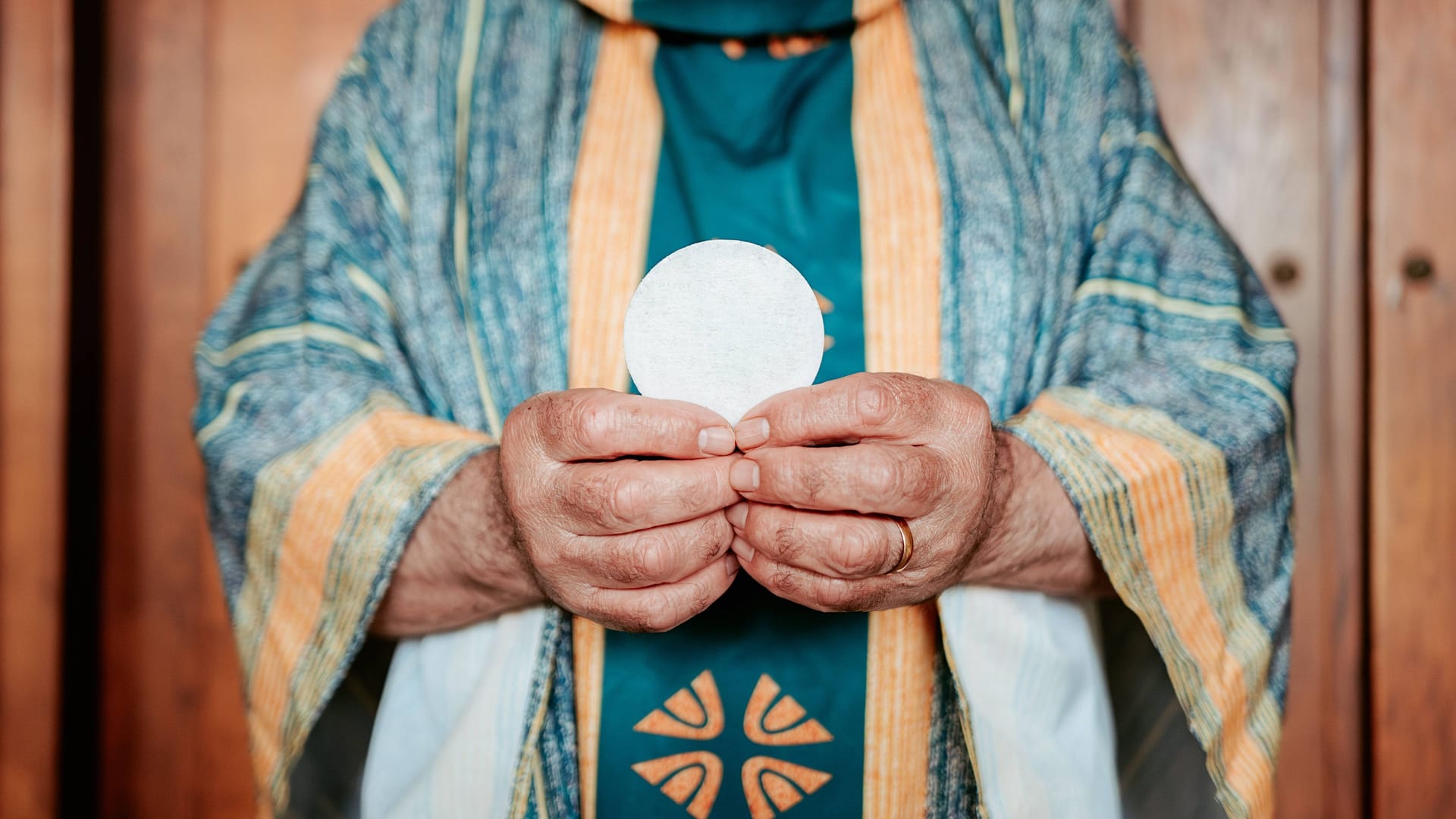 Ein Priester hält eine Hostie (Symbolbild): In Österreich wurde ein Geistlicher wegen eines Drogenvergehens festgenommen.