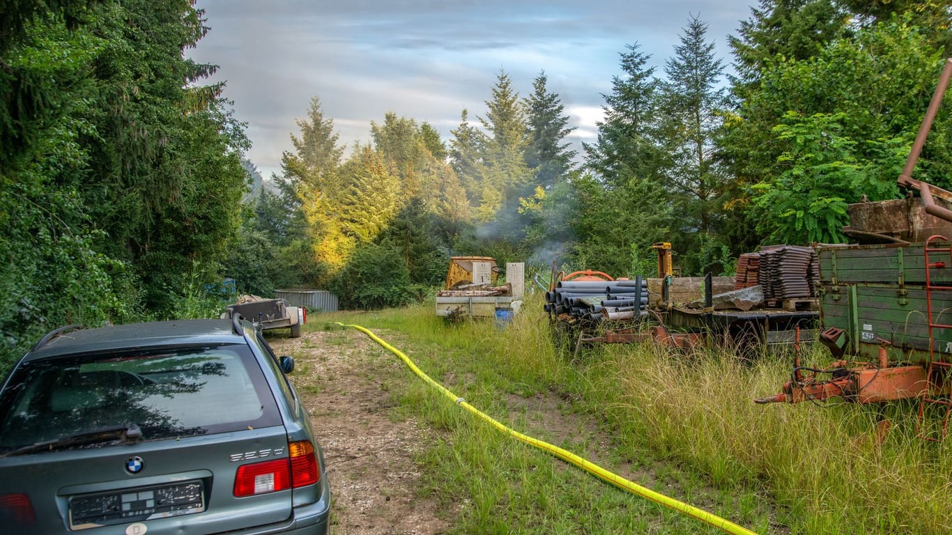 Qualm steigt von dem Gartengrundstück auf: Nach stundenlanger Fahndung hat die Polizei die "bis zur Unkenntlichkeit verbrannte" Leiche eines Mannes gefunden.