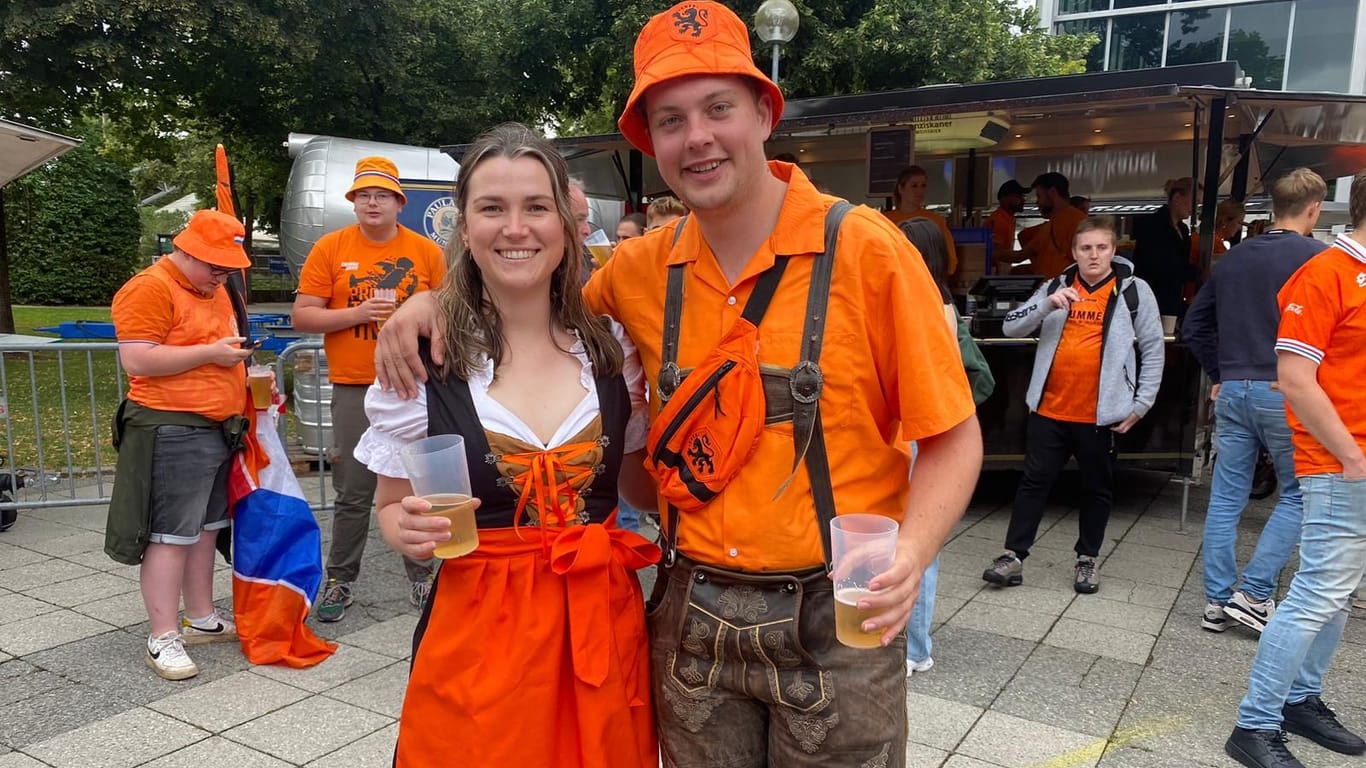 Julia und Tijn aus Utrecht feiern in orangefarbener Tracht.