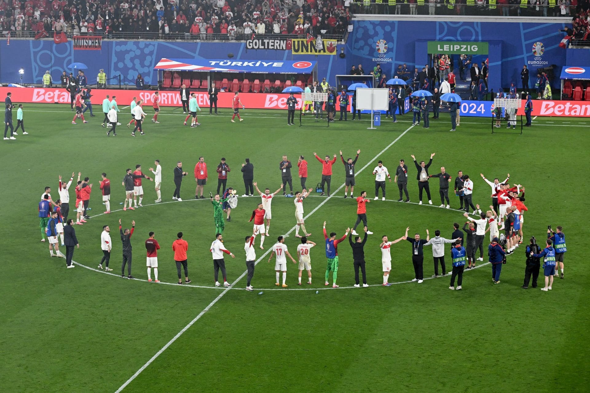 Die Spieler der türkischen Mannschaft stehen im Kreis zusammen und bejubeln den Sieg gegen Österreich.