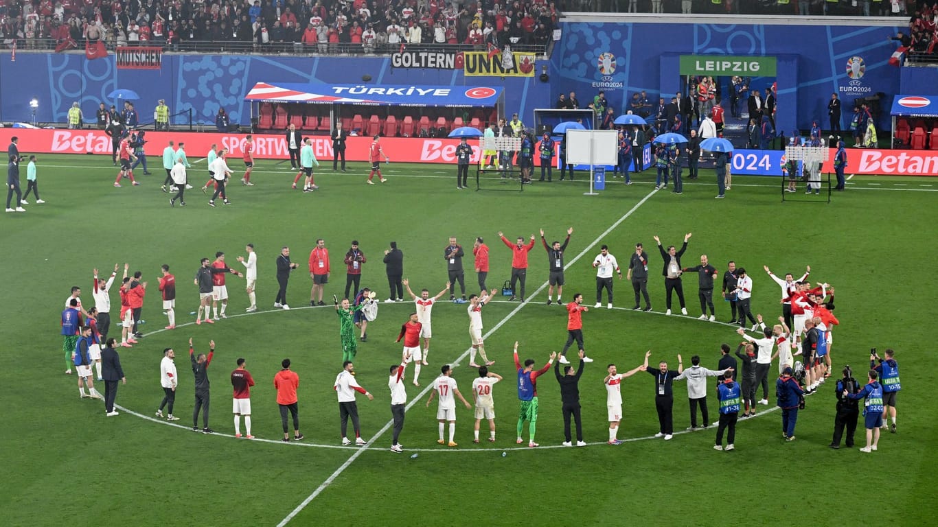 Die Spieler der türkischen Mannschaft stehen im Kreis zusammen und bejubeln den Sieg gegen Österreich.