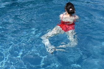 Eine junge Frau schwimmt in einem Freibad (Symbolbild): Nach langer Pause ist das Sommerbad Altengamme wieder geöffnet.