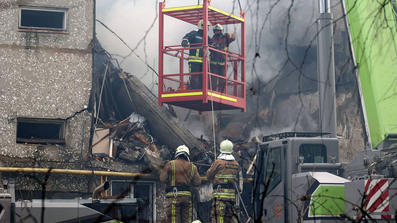 Feuerwehrleute stehen an einem zerstörten Gebäude in Sumy (Archivbild): Die Strom- und Wasserversorgung in der Stadt ist unterbrochen.